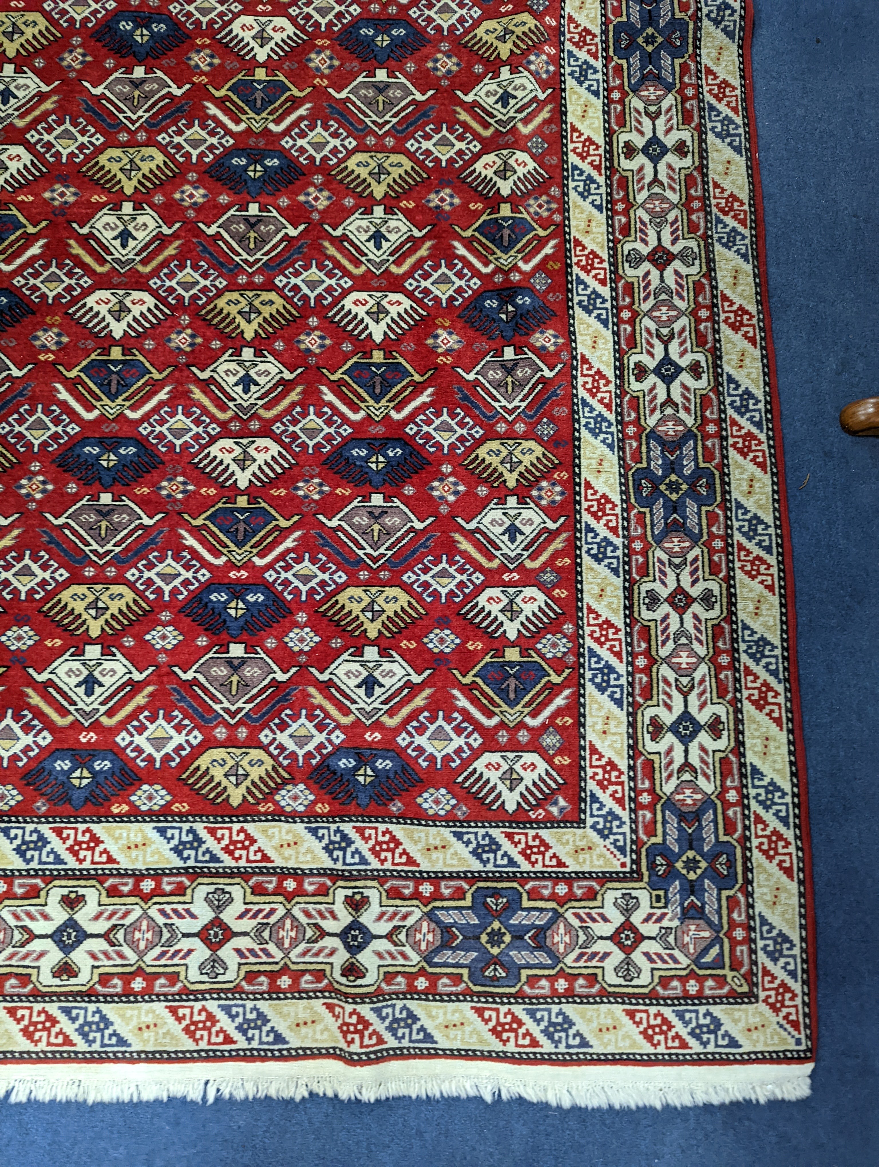 A Caucasian style red ground rug, 210 x 140cm